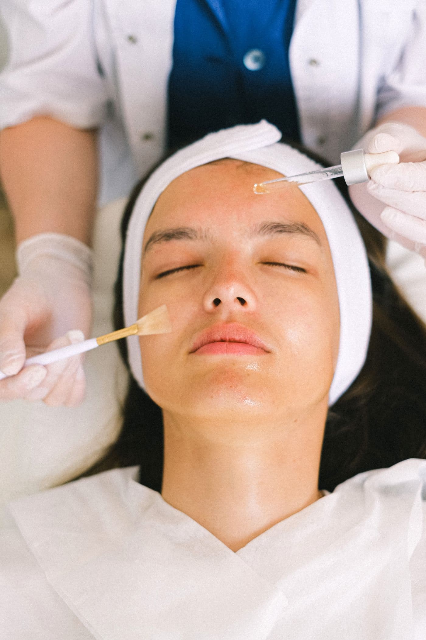 A serum being applied to the face during a facial